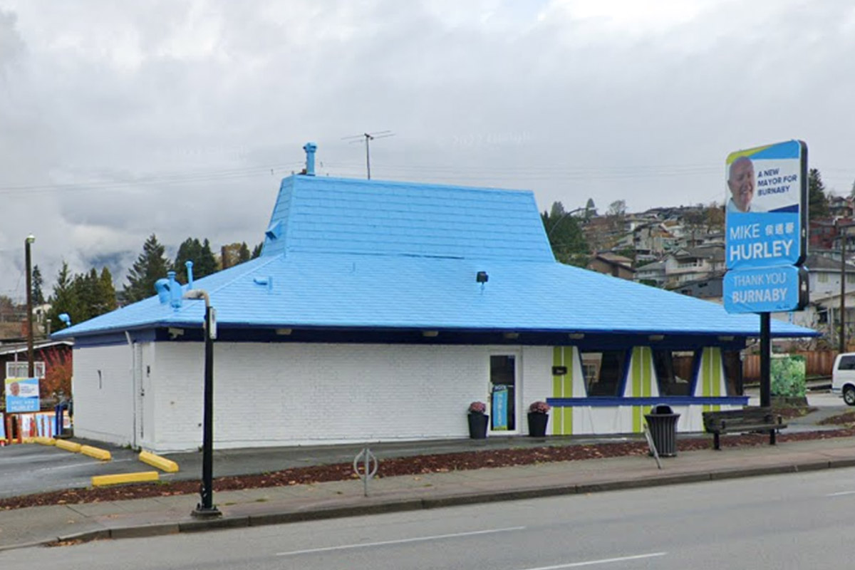 The pizza hut building has had its roof painted blue. The sign out front is a campaign sign for Mike Hurley.
