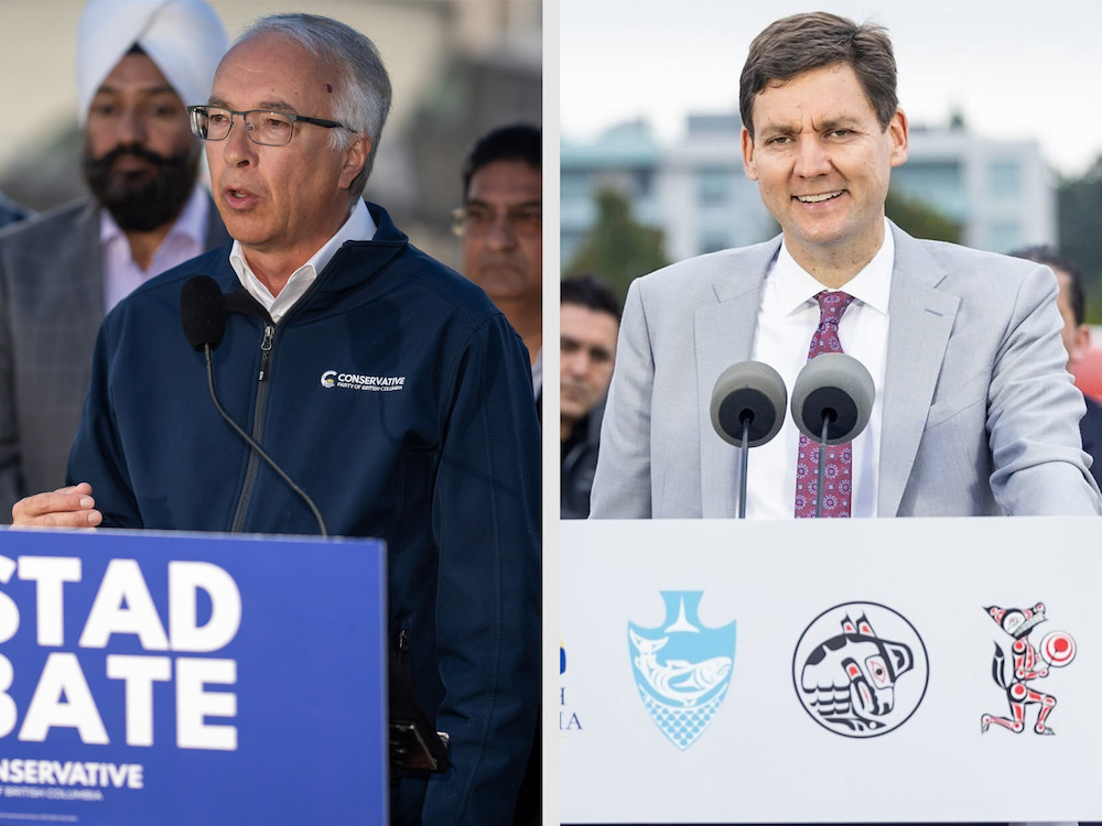 A two-panel image shows two men speaking at podiums. On the left, John Rustad has short grey hair and glasses and is wearing a navy fleece jacket bearing a small white 'Conservative Party of British Columbia' crest. He is speaking into a microphone at a podium with a blue sign that says 'Rustad rebate.' On the right, David Eby has short brown hair and wears a light grey suit over a white shirt and red paisley tie. He is standing at a podium inscribed with Indigenous artwork.