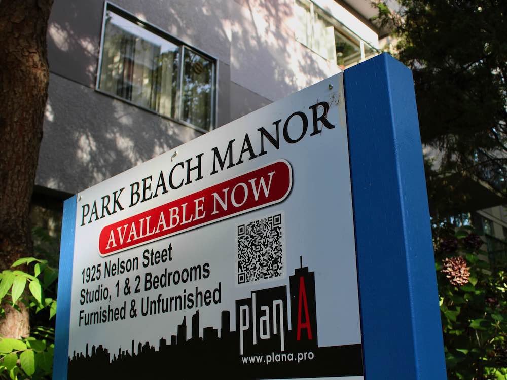 A sign outside an apartment building advertises suites for rent.