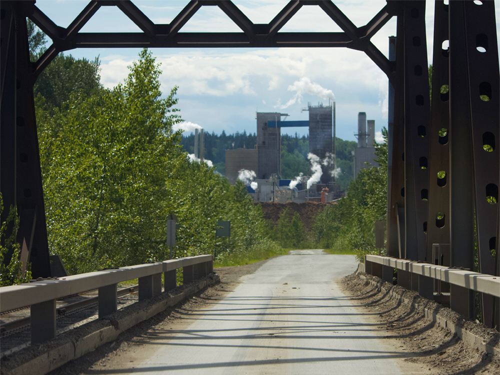 The view of the twin mills in Prince George, seen from a truss bridge.