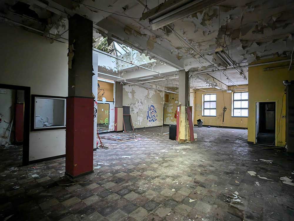 A large open space with damage to the ceiling, apparently from water.