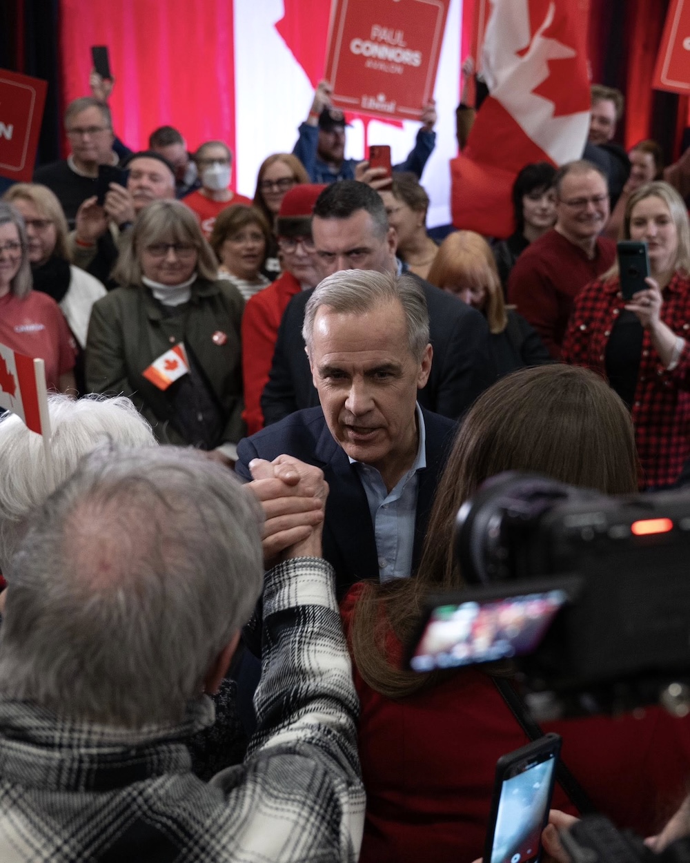 Mark Carney shakes supporters’ hands at a rally.