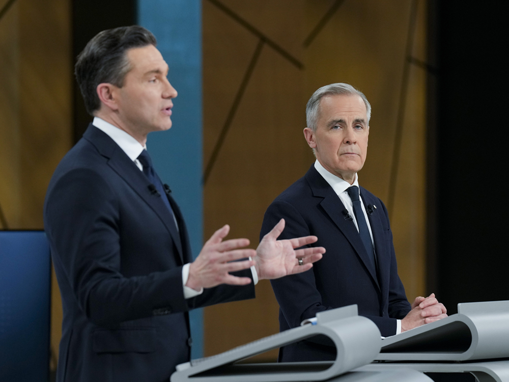 Conservative Leader Pierre Poilievre and Liberal Leader Mark Carney stand at podiums during the English-language debate.