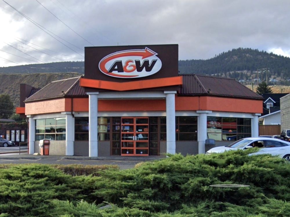 An A&W fast-food restaurant, with hills rising behind it.