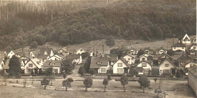 A black and white photo of arts-and-crafts style houses in a few rows.
