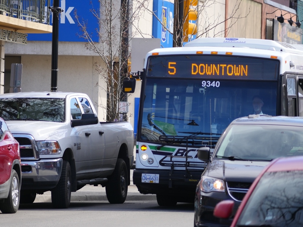 A city bus moves through dense traffic.
