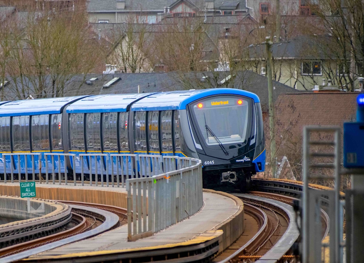 A blue Mark V SkyTrain car on an elevated track.