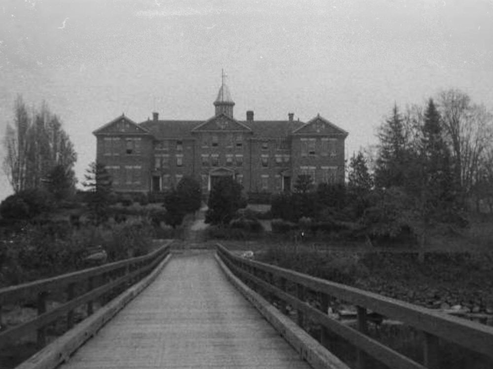 A black and white photo shows a large brick building that was built in the 1880s.