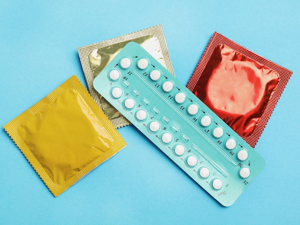 A photo shows birth control pills and condoms in packages.