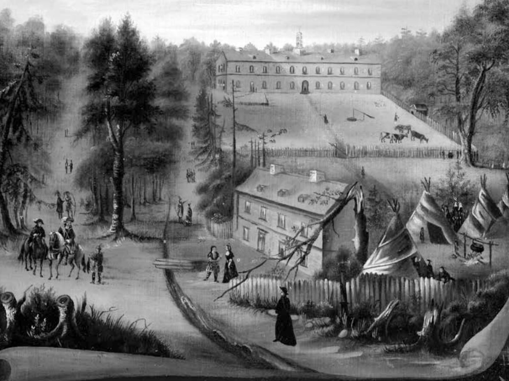 A painting depicts an institutional building in the far background, with a smaller building and a few teepees in the foreground. A few people are dressed in old-fashioned western attire; others appear to be Indigenous.