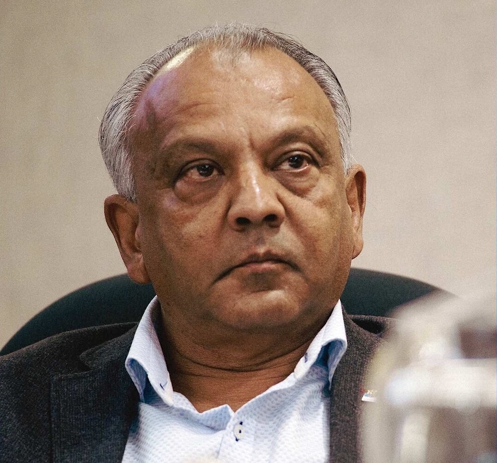 Bill Sarai, a middle-aged man with medium-dark skin tone and thinning grey hair.