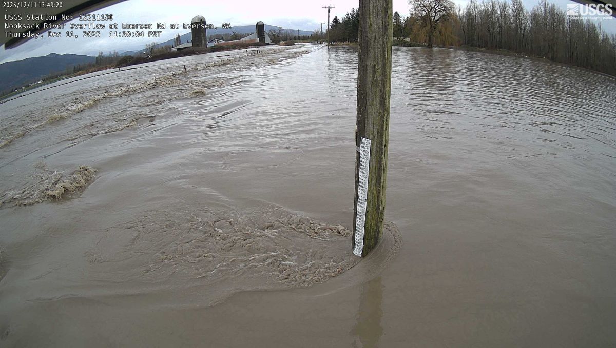 Rushing floodwater completely covers farmer&rsquo;s fields, ticking up a flood level marker.