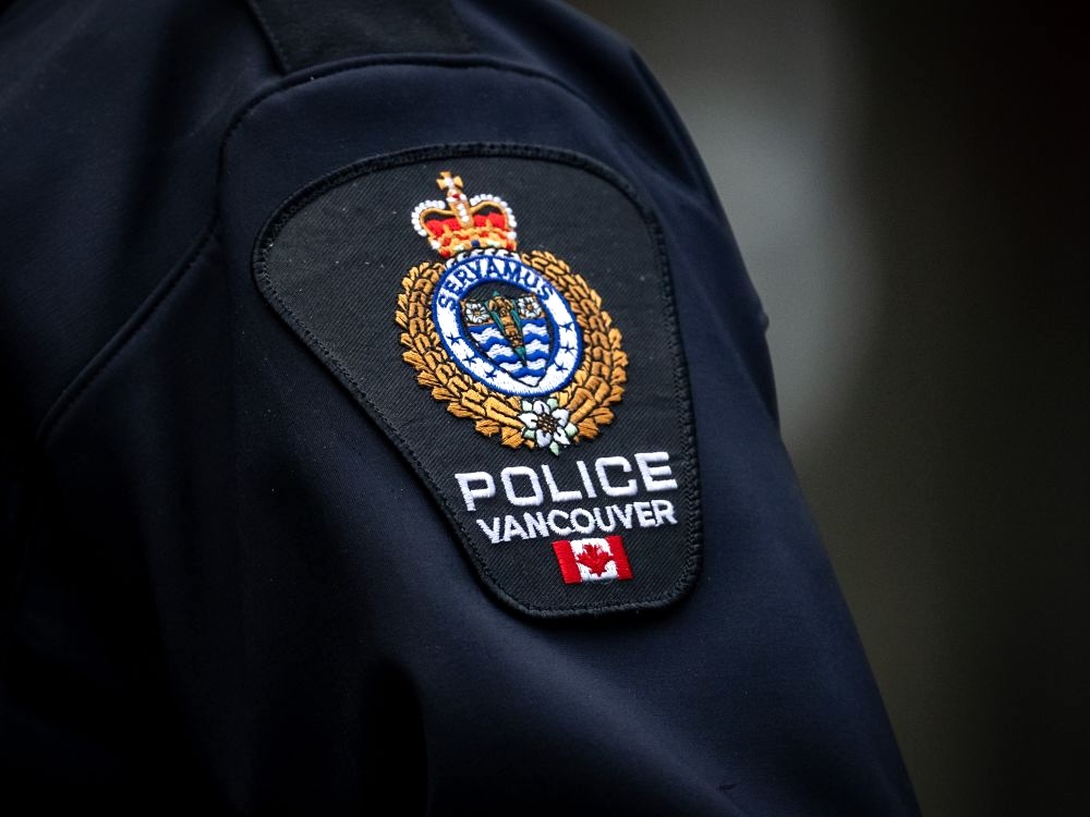 A close-up photograph of a police officer&rsquo;s shoulder shows the Vancouver Police Department&rsquo;s uniform badge.