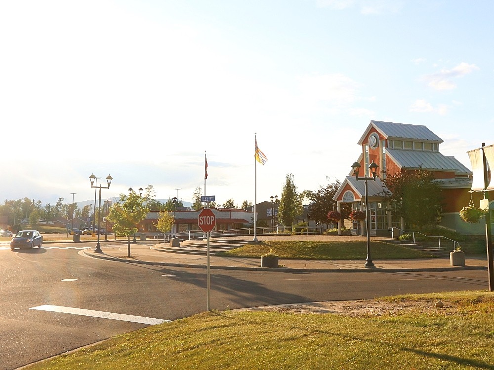 A salmon-coloured building faces onto a curved road with blue sky in the background.