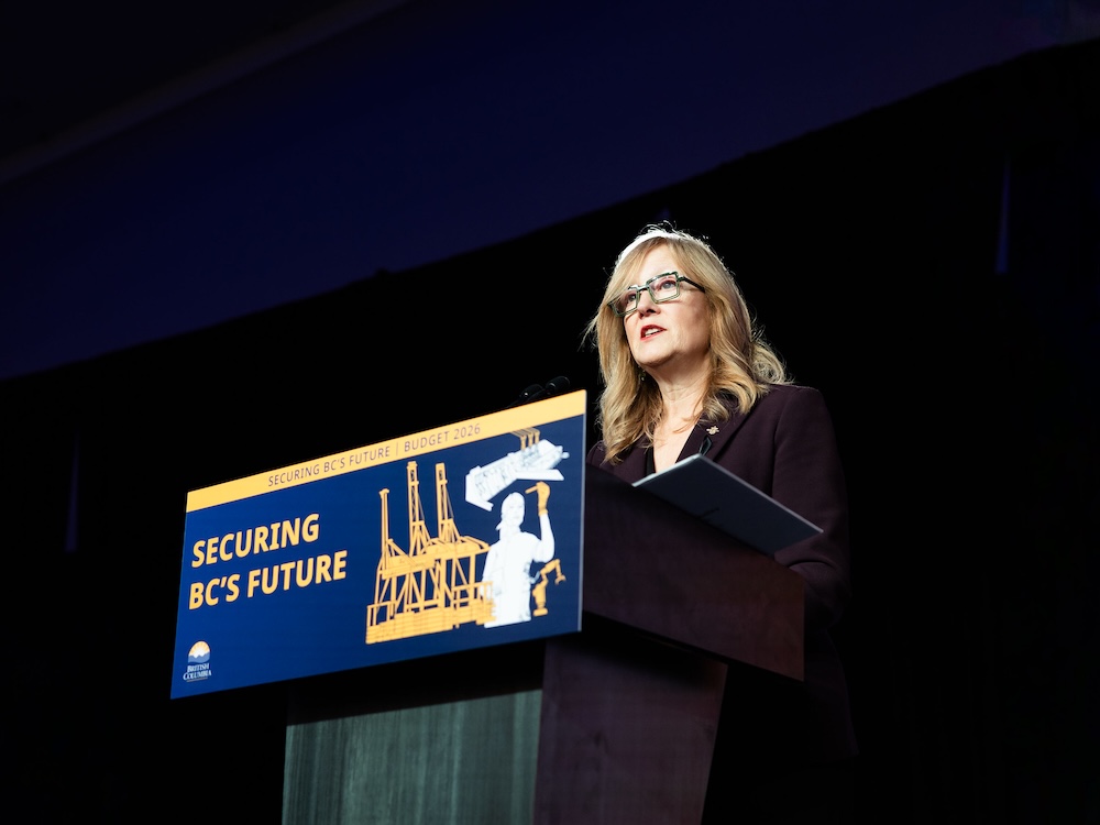 Brenda Bailey, a light-skinned woman in her late 50s, stands at a podium.