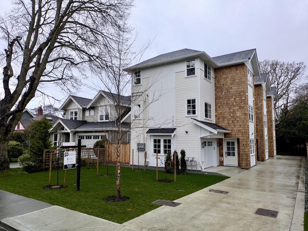 A photo shows a large three-storey triplex development on a small lot.