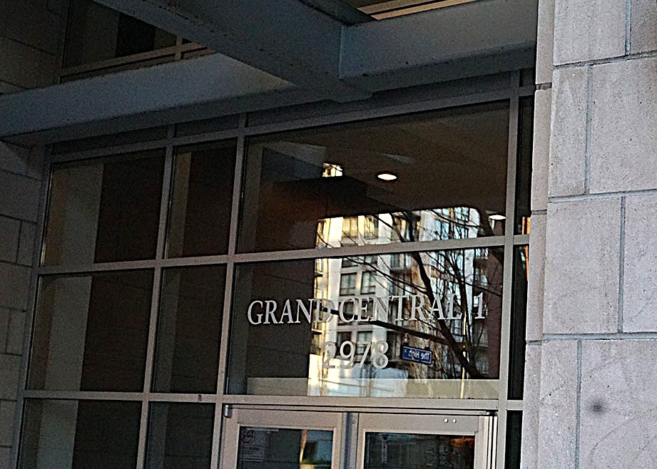 The darkened entrance of a condo building bears the words &lsquo;Grand Central 1&rsquo; and the building&rsquo;s address. 