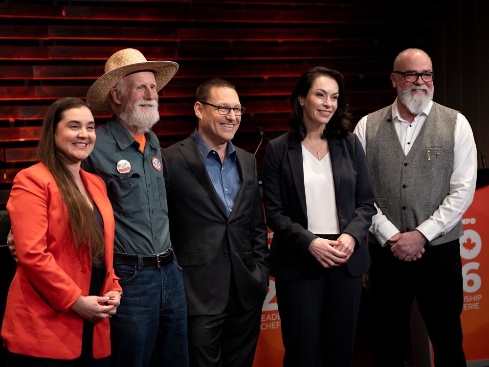 The five NDP leadership candidates stand side by side, smiling.