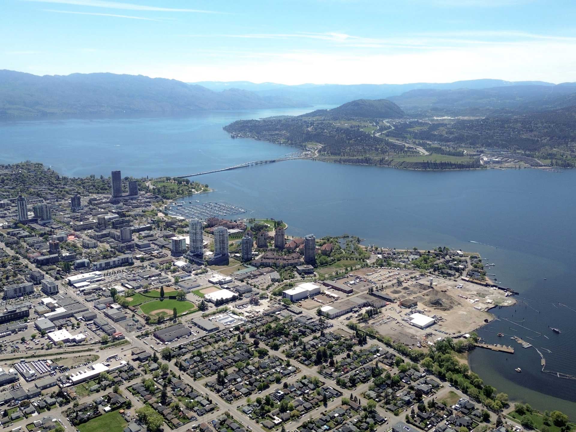 An aerial photo shows urban areas on the side of Okanagan Lake.