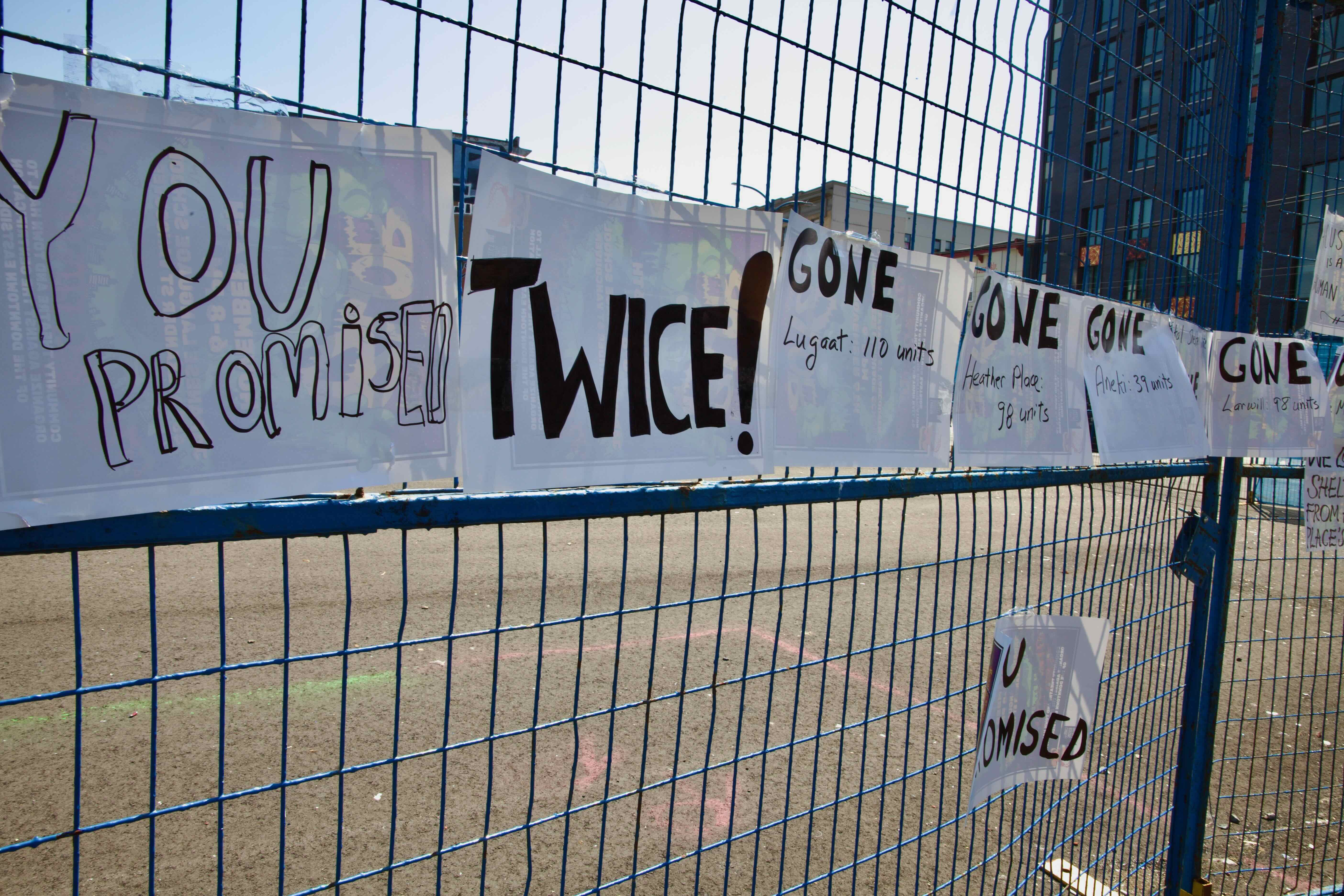 A fence in front of an empty lot has signs listing housing that has been lost.