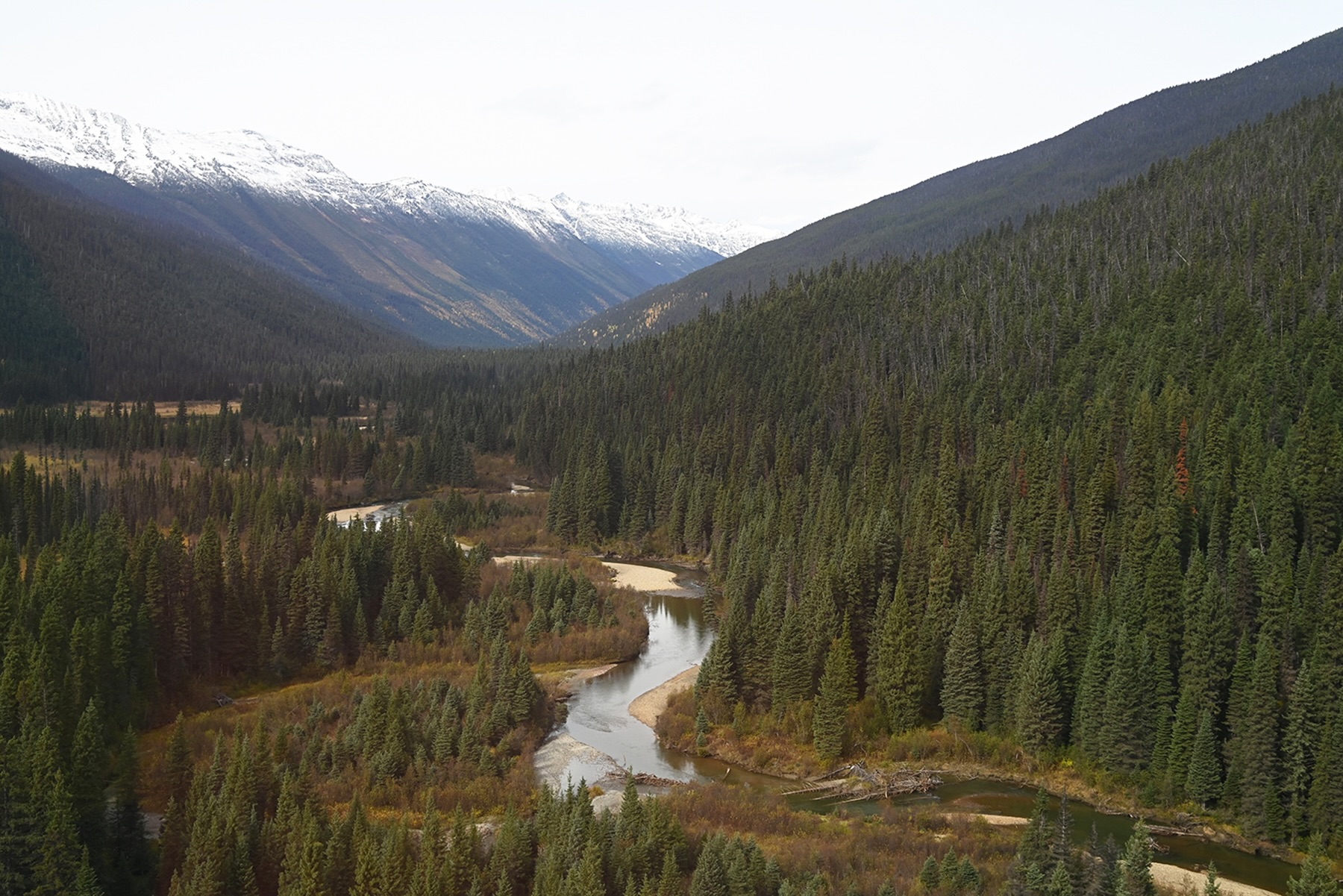 A river runs through a mountain valley. Mountains flank it on either side.