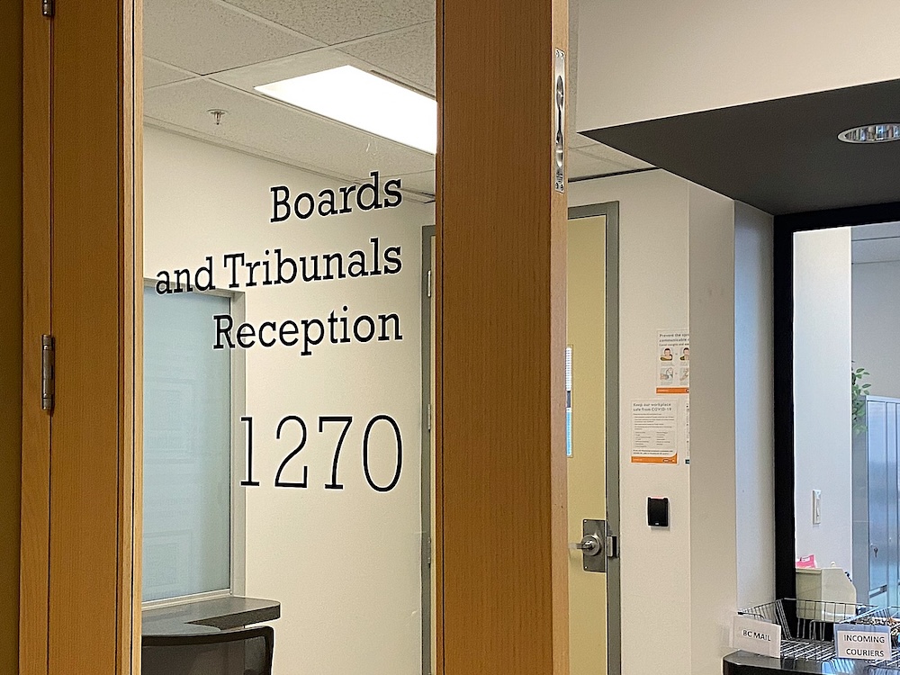 An office door with lettering that reads &lsquo;Boards and Tribunals Reception.&rsquo;