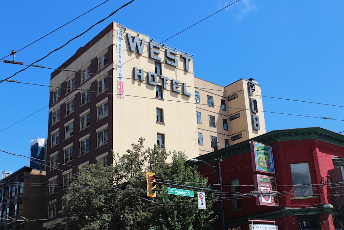 A large brick building with a large sign on the side of the building that says &lsquo;West Hotel.&rsquo; 