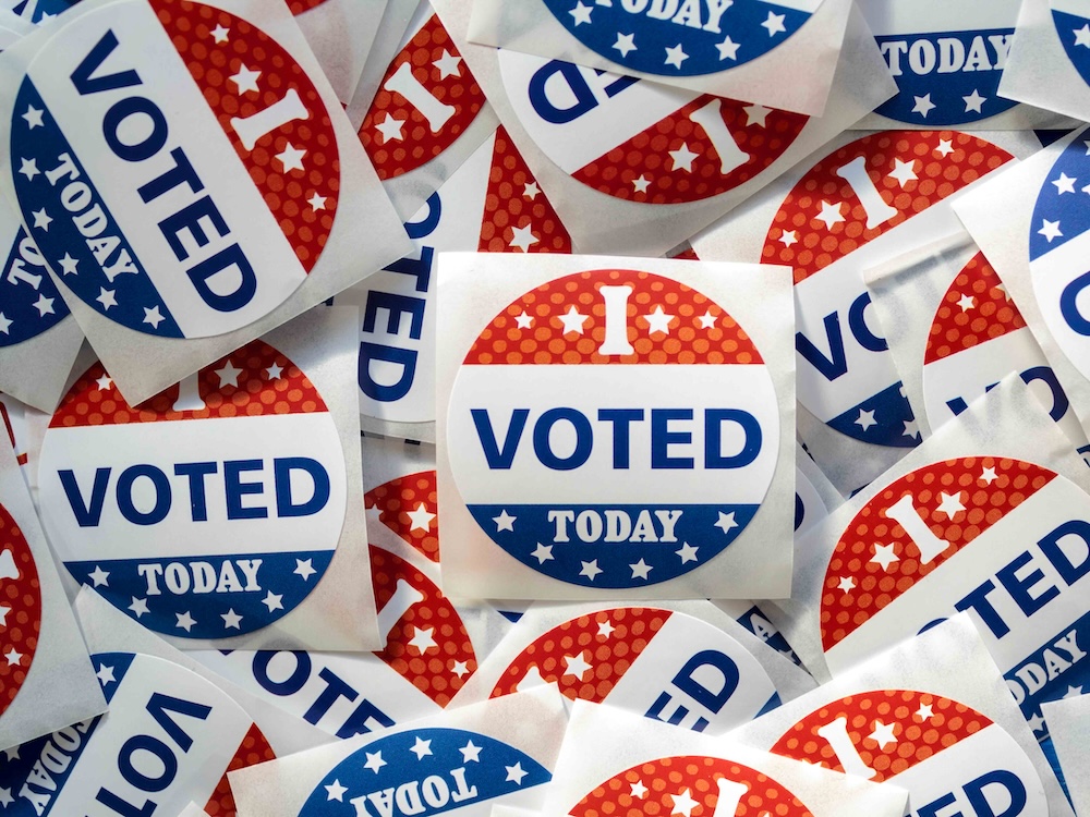 A pile of circular stickers that read 'I voted today' feature the red, white and blue stars and stripe patterns reminiscent of the American flag.