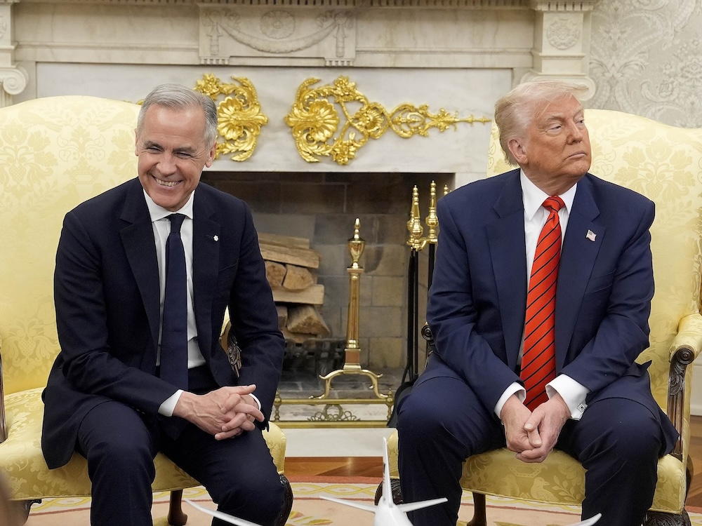 Prime Minister Mark Carney smiles as U.S. President Donald Trump looks away. Both are seated in an ornately decorated office.