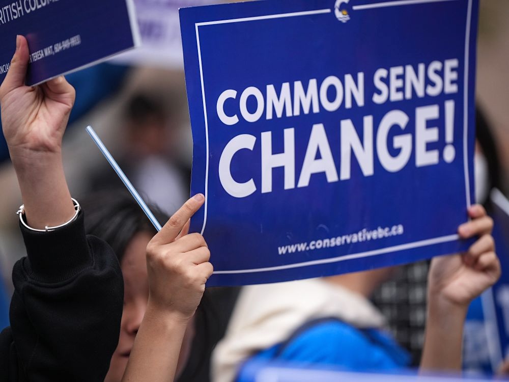 A blue and white placard says &lsquo;Common Sense Change!&rsquo;