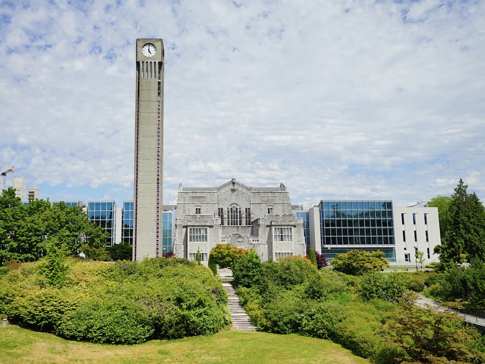 The campus of the University of British Columbia. The photo shows a clock tower and several buildings.