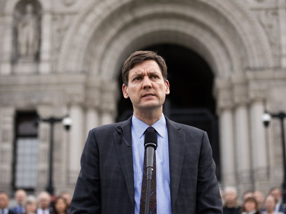 David Eby, a 49-year-old light-skinned man stands outside the B.C. legislature.