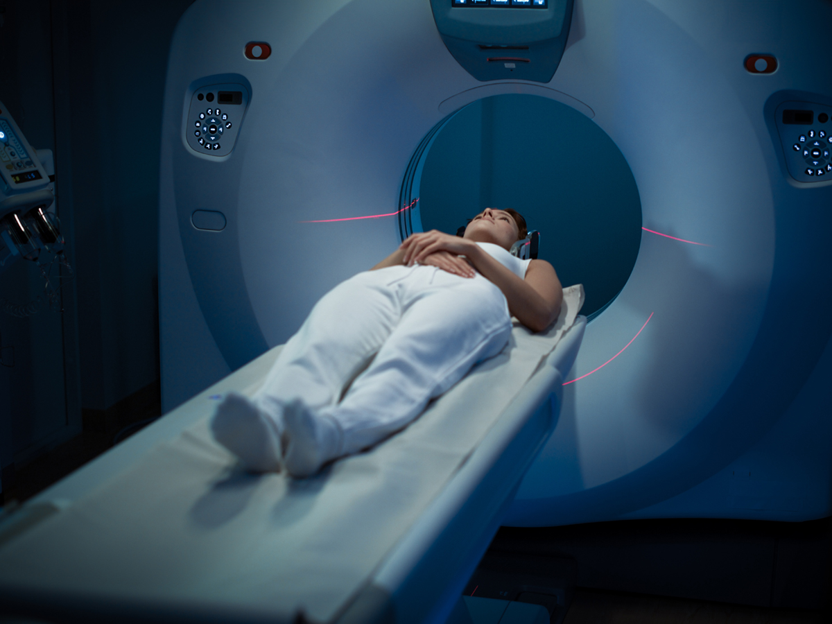 A person is on a stretcher at the opening to an MRI machine.