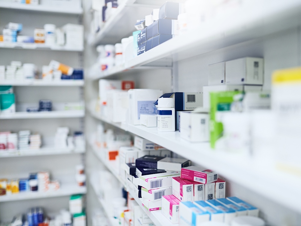 A shelf in a pharmacy, stocked with boxes of medications.