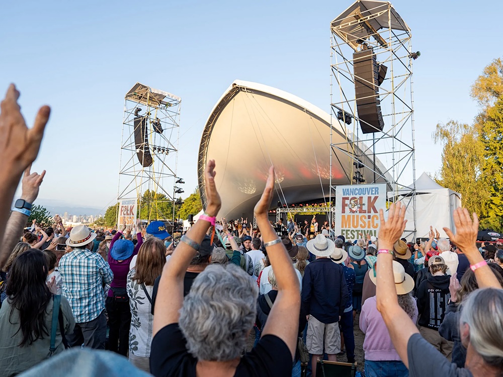 Audience members at the 2025 Vancouver Folk Music Festival clap their hands along to the music. 