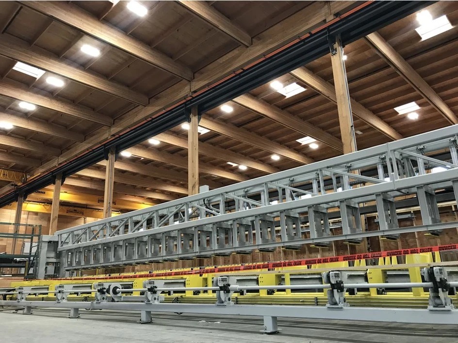 A large press inside of a workshop with a wood roof.