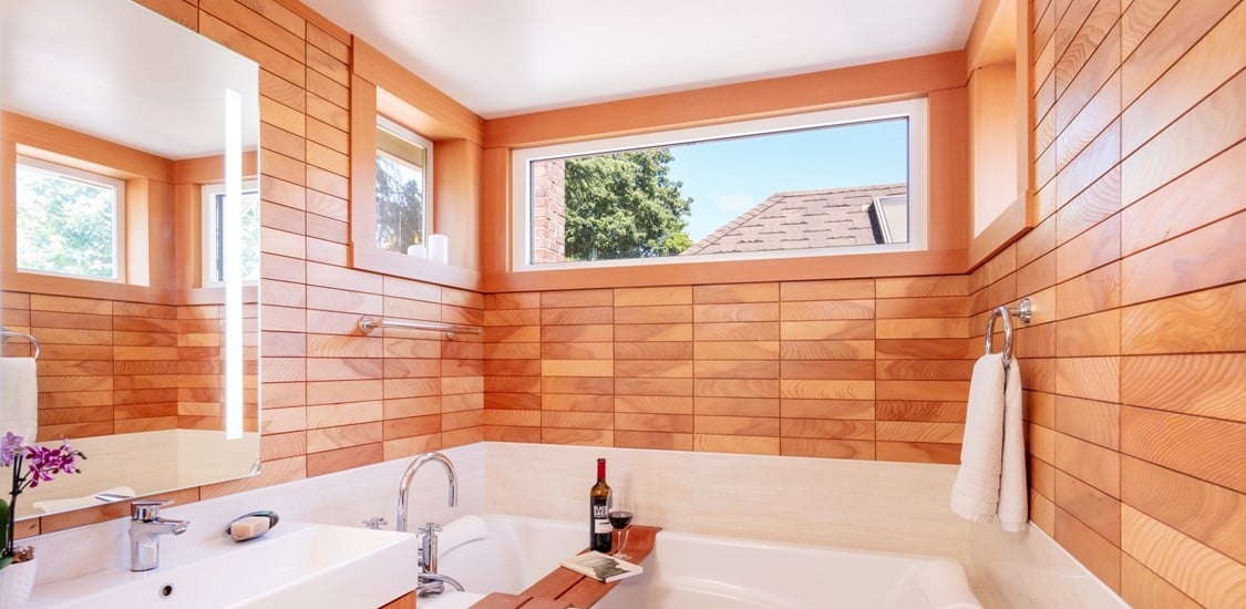 A beautifully finished bathroom featuring wooden tiles on the walls.