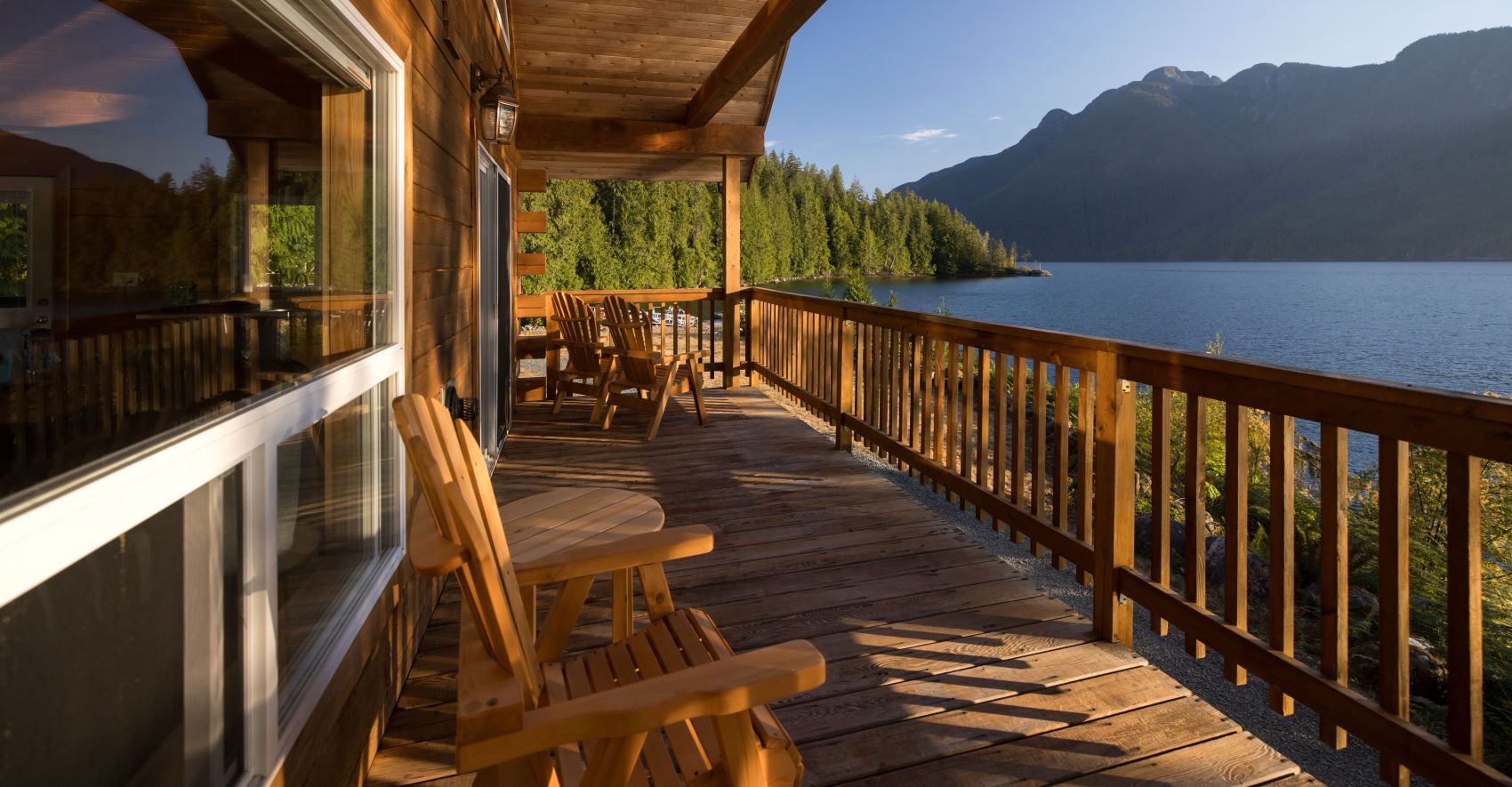 The Klahoose Wilderness Resort’s wooden veranda with Adirondack chairs looking out over the water.