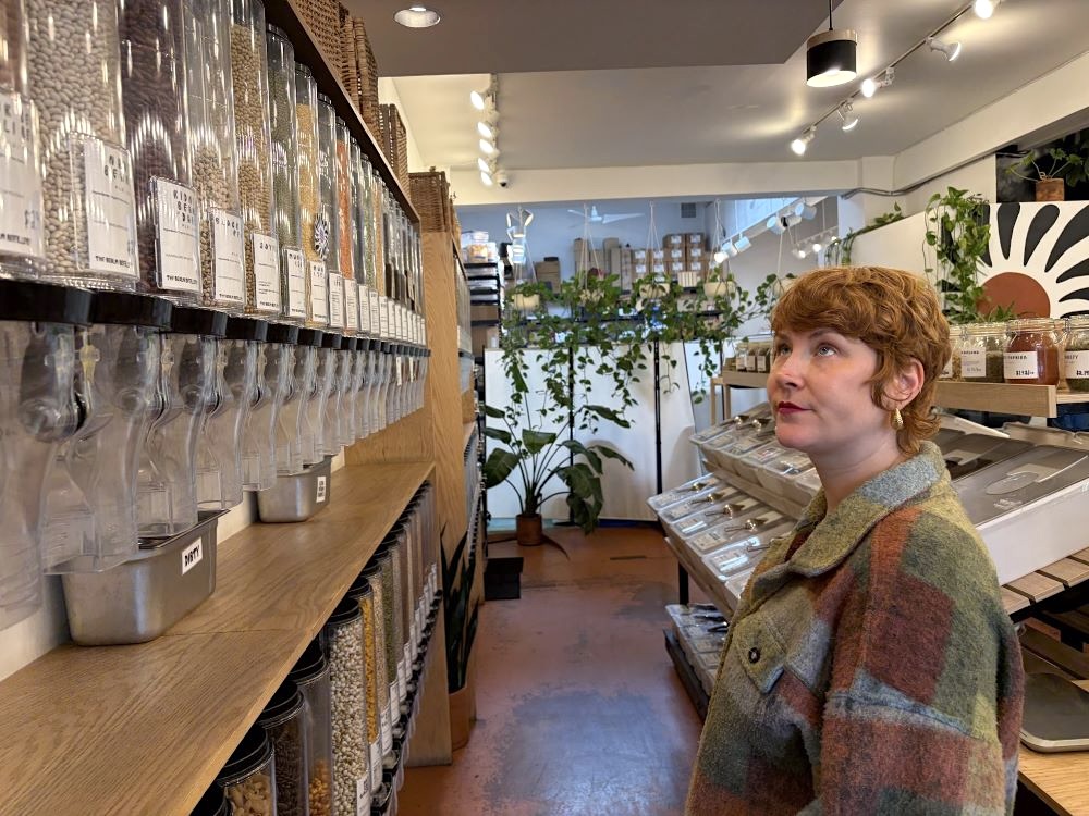 A customer looks up to a wall filled with dispensers of beans.